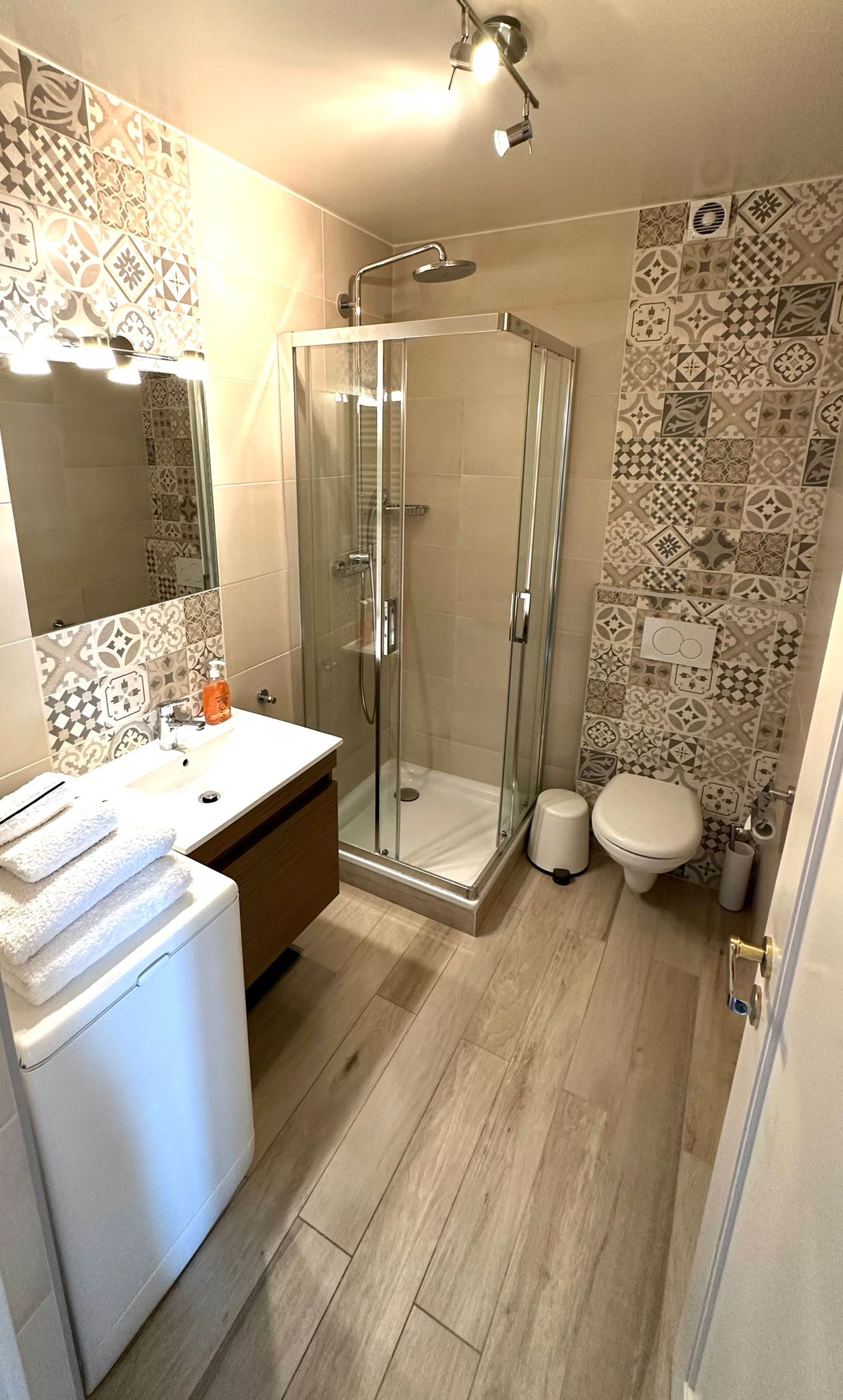 Salle de bain entièrement refaite à neuf, douche, WC, lavabo avec petit meuble intégré, miroir, chauffe-serviettes,  machine à laver