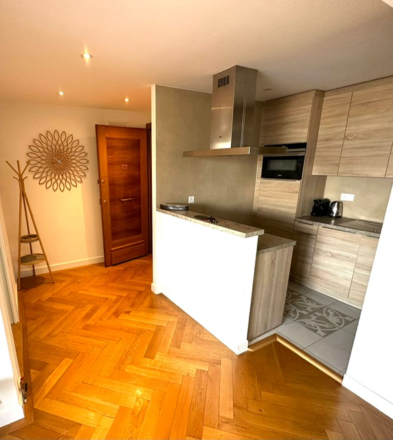 Spacieuse entrée desservant la chambre à coucher, le salon et la cuisine, parquet en chevron